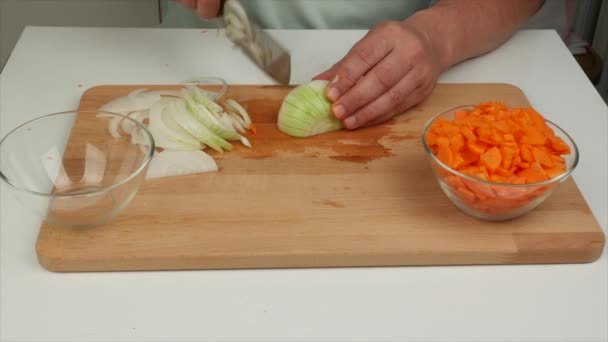 Mies leikkaa sipulia japanilaisella veitsellä nakiripulia puulaudalla, lähikuva terveellistä ruokavaliota ruokaa - Materiaali, video