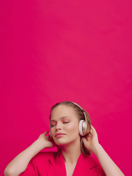A beautiful young girl in wireless headphones listens to song with a good mood. bright colorful music poster. - Fotografie, Obrázek