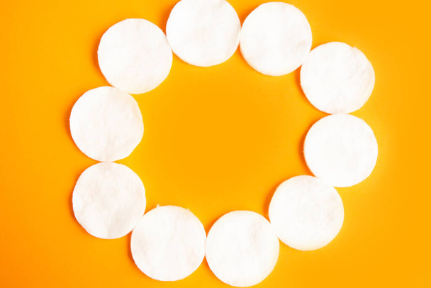 Marco de esponjas de algodón sobre fondo naranja, vista superior
 - Foto, Imagen