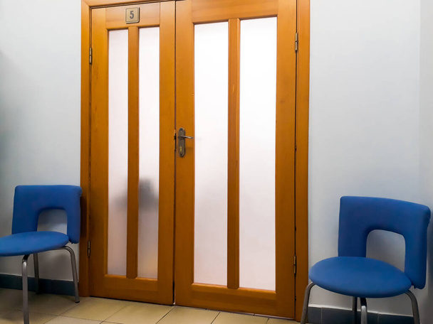Detalhe do interior, design - portas de madeira largas e duas cadeiras de escritório ao lado deles. Escritório, corredor, quarto
 - Foto, Imagem