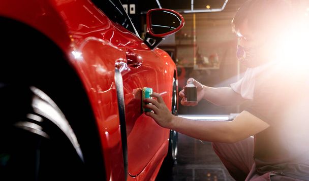 Car service worker applying nano coating on a car detail - Φωτογραφία, εικόνα