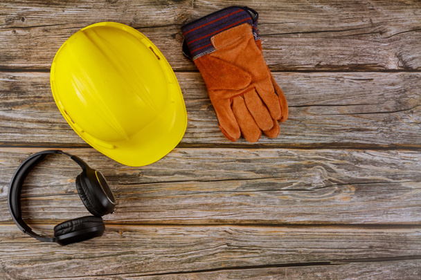 Equipo seguridad construcción estándar seguridad orejeras cuero seguridad casco guantes de protección en madera mesa vista superior
 - Foto, imagen