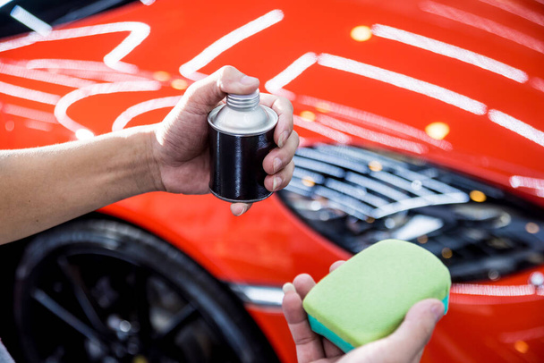 Car service worker applying nano coating on a car detail - Foto, imagen
