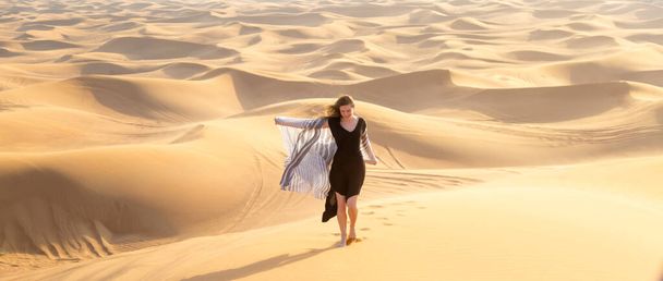 Cheerful free girl runs in the desert. The joy of freedom, the concept of a free happy life away from city life. - Fotoğraf, Görsel