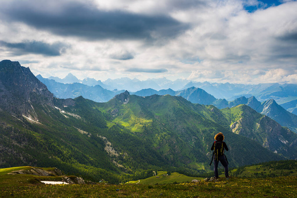 Mujer con mochila descansando en la cima de la montaña, mirando al paisaje dramático valle actividad de verano fitness bienestar concepto de libertad, vista trasera - Foto, Imagen