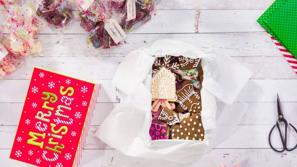 Deitado. Passo a passo. Embalagem de chocolate caseiro e biscoitos em uma caixa de presente de Natal. - Foto, Imagem