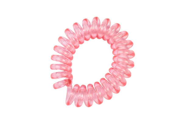 Różowa spirala elastyczna. Elastyczna opaska do włosów na białym tle zbliżenie, przestrzeń do kopiowania tekstu - Zdjęcie, obraz