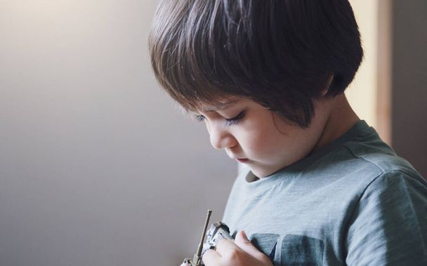 Πορτρέτο του μοναχικού αγοριού παιδί με λυπημένο πρόσωπο παίζει μόνο του, Bored Child κοιτάζοντας δεξαμενή παιχνίδι με τη σκέψη πρόσωπο. - Φωτογραφία, εικόνα