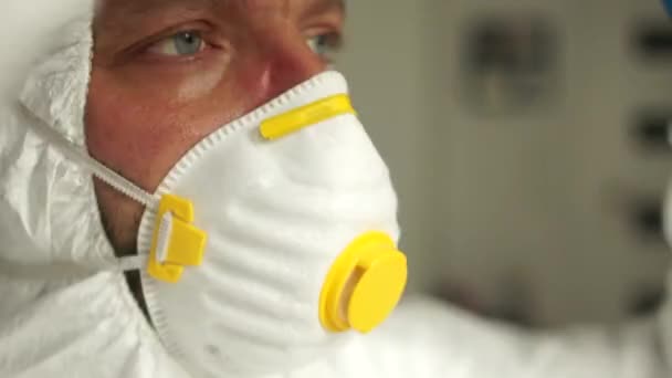 Male doctor during a coronavirus pandemic covid-19 takes off glasses and a protective mask, face marks are visible from the mask, red spots. Close portrait of a tired doctor - Filmati, video