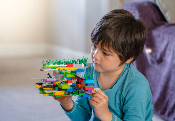 Aktif küçük çocuk inşaat plastik oyuncak bloklarıyla oynuyor, çocuk oyun odasında renkli oyuncaklar oynuyor, bebek gelişimi konsepti... - Fotoğraf, Görsel