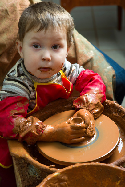 Una mano di vasaio guida le mani dell'allievo per aiutarlo a lavorare con la ruota in ceramica
 - Foto, immagini