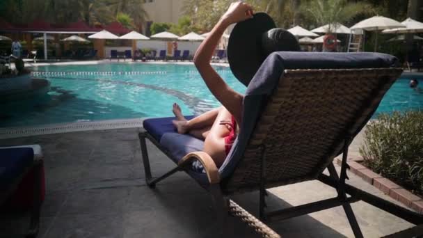 κορίτσι σε μια ξαπλώστρα δίπλα στην πισίνα - Πλάνα, βίντεο