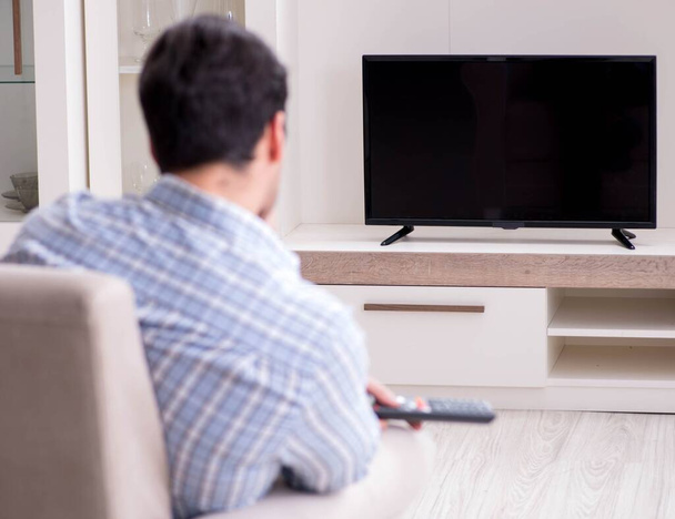 Hombre joven viendo la televisión en casa - Foto, Imagen