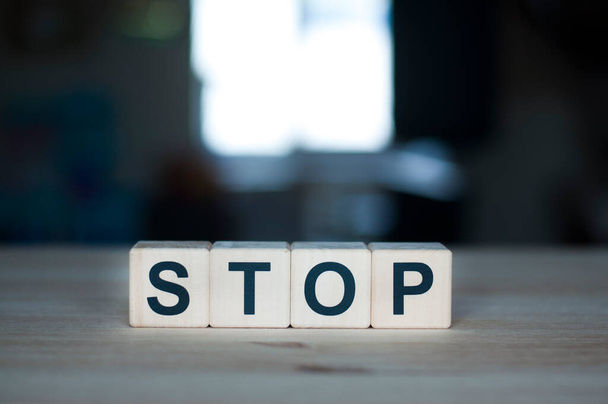 Das Wort Stop auf einem Holzwürfel. Briefkonstrukteur - Foto, Bild