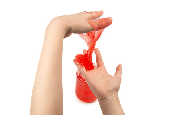 Rotes Schleimspielzeug in Frauenhand isoliert auf weißem. Ansicht von oben.  - Foto, Bild