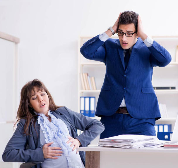 妊娠中の女性がオフィスで苦労して同僚になって - 写真・画像