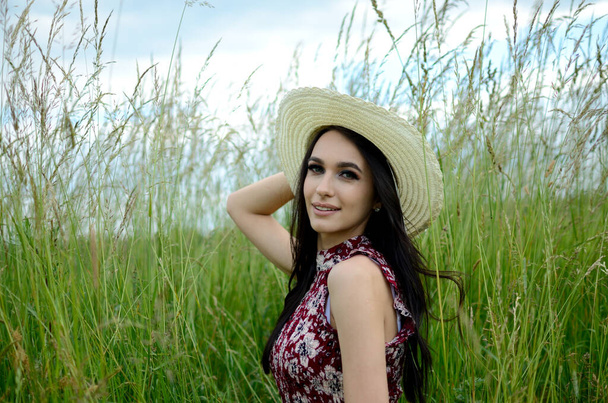 Kaunis nainen kesähattu päässä maaseudulla. Muotokuva nuori puolalainen nainen ympäröi vihreä ruoho.  - Valokuva, kuva