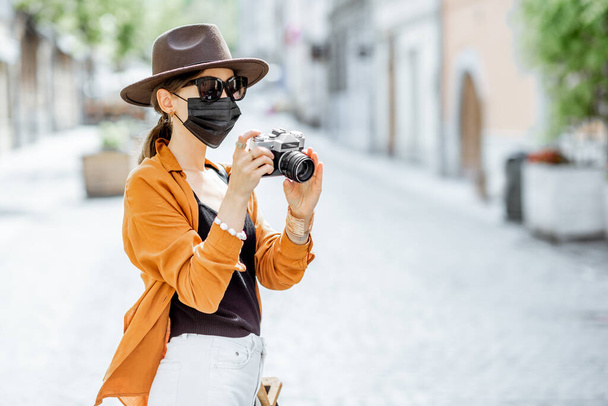 Жінка в масці для обличчя подорожує в старому місті
 - Фото, зображення