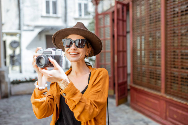 Стильная женщина с фотокамерой на открытом воздухе - Фото, изображение