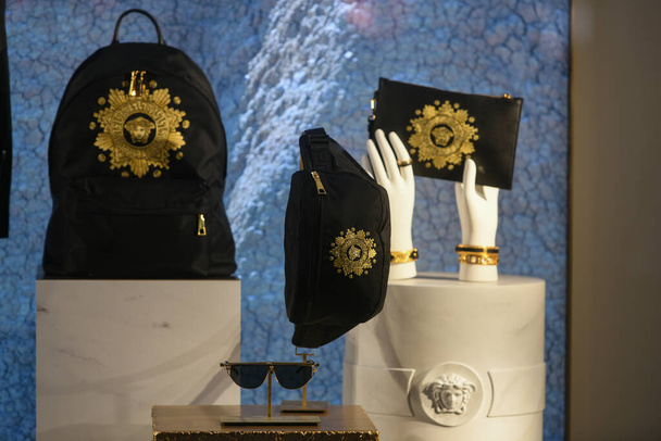 Milan, Italy - January 11, 2020: Black and golden Versace accessories displayed in a showcase - Photo, Image