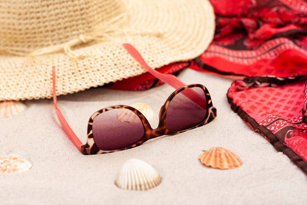 Vintage summer wicker straw beach hat, pareo and sunglasses on the seashore of Catania, Sicily, Italy - Фото, изображение