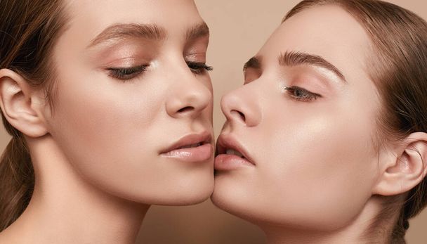 Close-up Studioporträt von zwei schönen sinnlichen jungen Mädchen mit klarer, frischer junger Gesichtshaut und perfektem Nude-Make-up - Foto, Bild