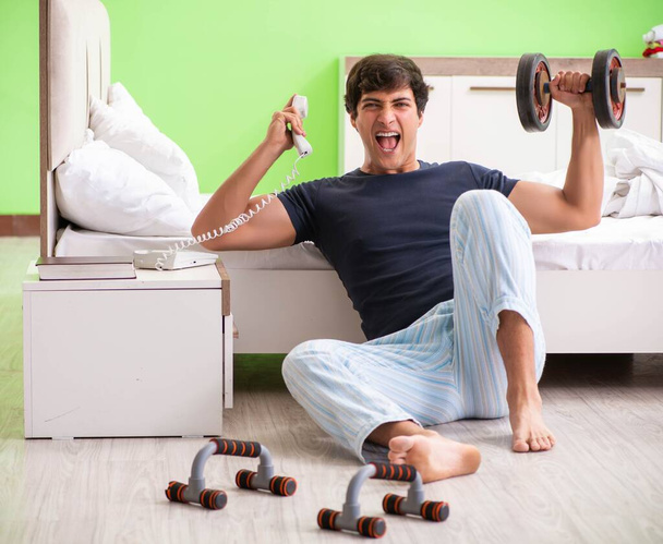 Mladý muž v pyžamu dělá ranní cvičení - Fotografie, Obrázek