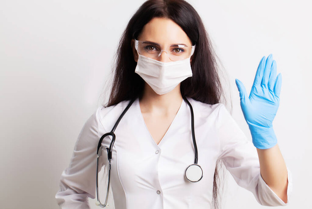 Female doctor in white coat shows hands stop gesture - Foto, Bild