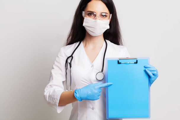 Жінка-лікар тримає чистий аркуш паперу з місцем для тексту
 - Фото, зображення