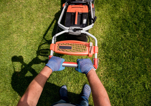 Gardener mowing the lawn. Landscape design. Green background - Fotó, kép