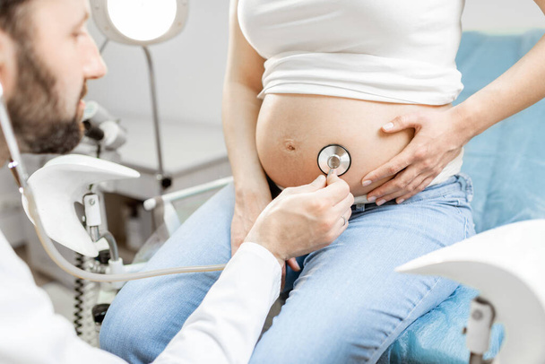 Docteur écoute un ventre de femme enceinte - Photo, image