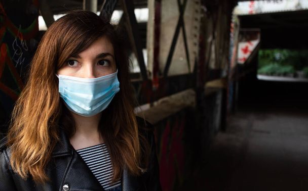 Atraktivní mladá žena jde na procházku kanálem Regents, zatímco na sobě masku obličeje během epidemie koronaviru - Fotografie, Obrázek