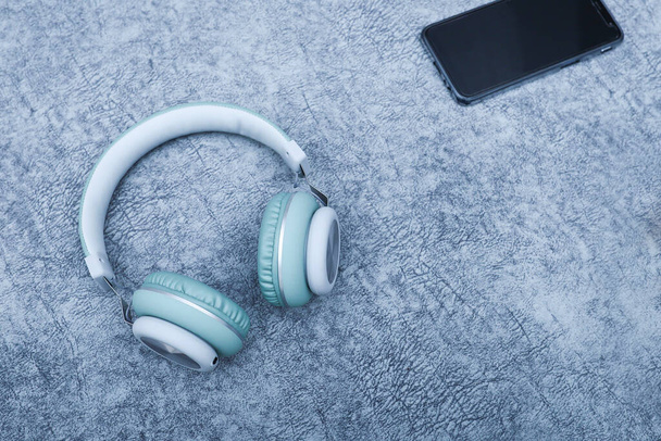 A headphone and a smartphone on grungy background - Photo, Image