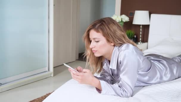 young woman uses a smartphone, communicating in the instant messengers and use the mobile app - Video