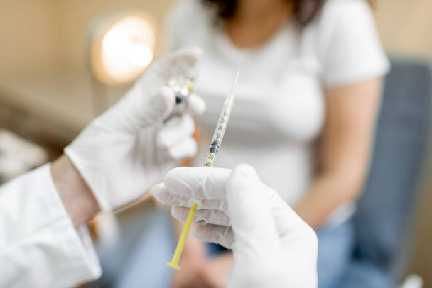 Doctor holding vaccine or some medication in the syringe - Foto, afbeelding
