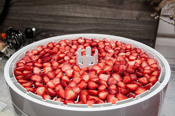 Αποξηραμένες φράουλες κομμένες σε κομμάτια. Ένα στεγνωτήριο για ένα νόστιμο και υγιεινό επιδόρπιο. Κοντινό πλάνο. - Φωτογραφία, εικόνα