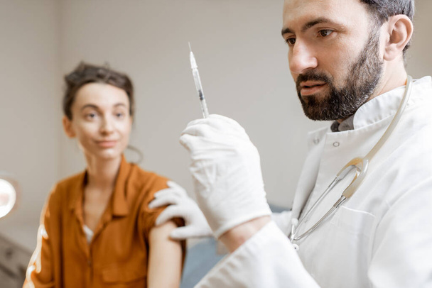 Doctor holding vaccine or some medication in the syringe - Foto, Imagen
