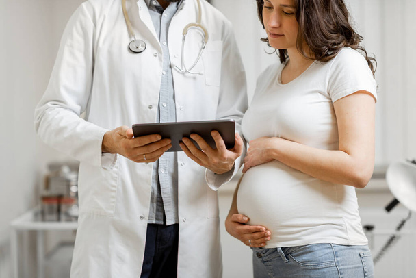 Lekarz z kobietą w ciąży podczas konsultacji lekarskiej - Zdjęcie, obraz