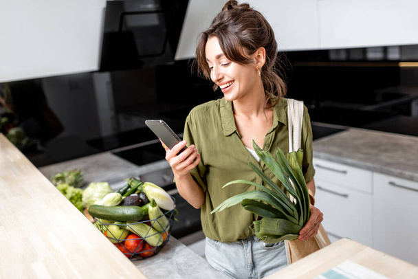 Woman with fresh groceries on the kitchen at home - Foto, Bild