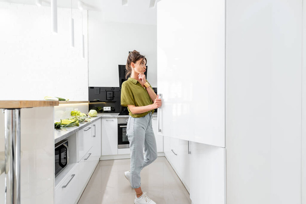 Женщина готовит на белой кухне - Фото, изображение