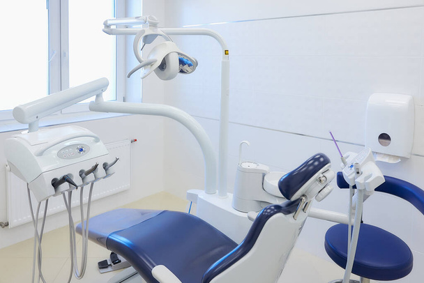Сучасний інтер'єр стоматологічного кабінету з біло-блакитними меблями, стоматологічним кріслом, дрилями. Стоматологічний кабінет
. - Фото, зображення