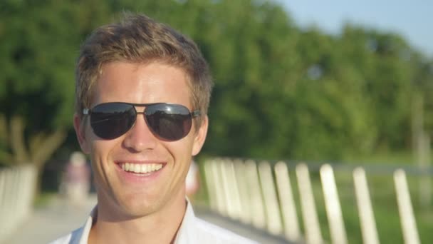 PORTRAIT: Fröhliche männliche Studenten lächeln, während sie einen Sommertag im Park genießen. - Filmmaterial, Video