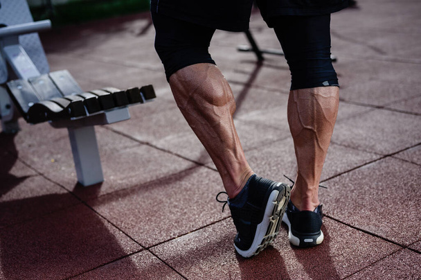 strong athlete active legs of man in sneakers on outdoor training workout sport street gym in summer - Foto, Bild