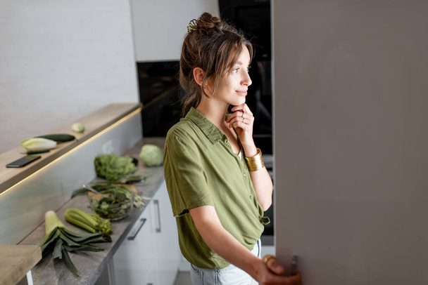 Mujer mirando en la nevera en la cocina en casa - Foto, Imagen