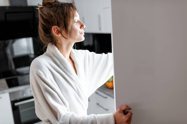 Frau schaut nachts in den Kühlschrank in der Küche - Foto, Bild