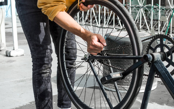 Mechanische man met een moersleutel voor het bevestigen van een fietswiel - Foto, afbeelding