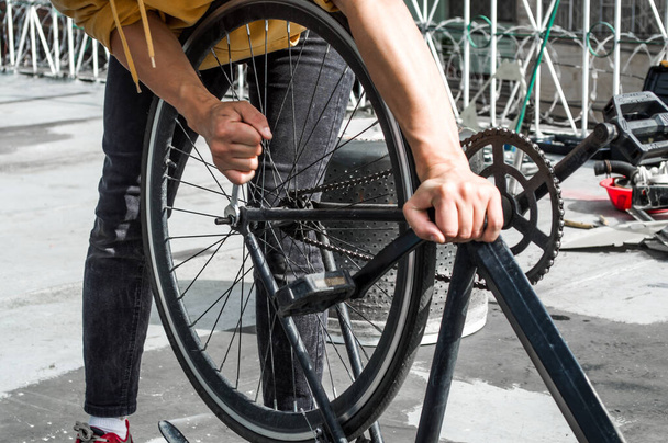 自転車の車輪を固定するスパナを持つ機械的な男 - 写真・画像