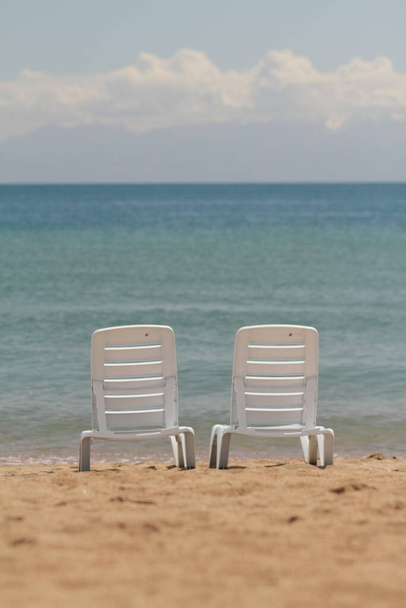 Палубне крісло в піску на березі. Розслабся, розслабся на пляжі. Синя вода в океанічному морі. Подорож до моря острова. Відпочинок на морі. Повітряний туризм. Високоякісна фотографія
 - Фото, зображення