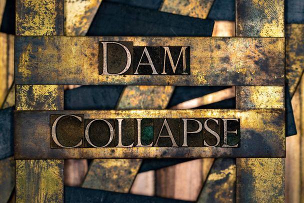 Dam Collapse Text mit echten authentischen Schriftbuchstaben auf silbernem Grunge-Kupfer und Goldhintergrund - Foto, Bild