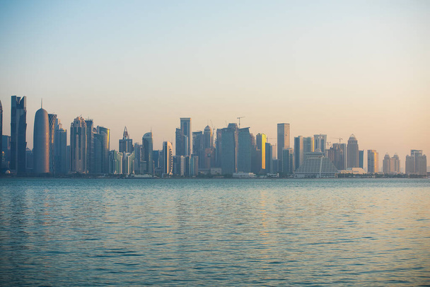 Morgengrauen in Doha. Blick auf die Innenstadt. Die Sonnenstrahlen fallen schräg nach hinten. Westbucht - Foto, Bild